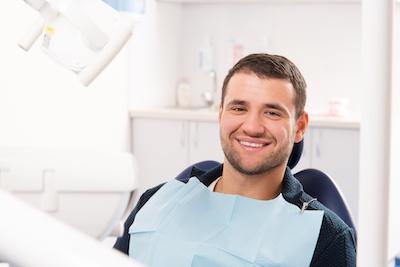 man smiling in dental chair in newcastle
