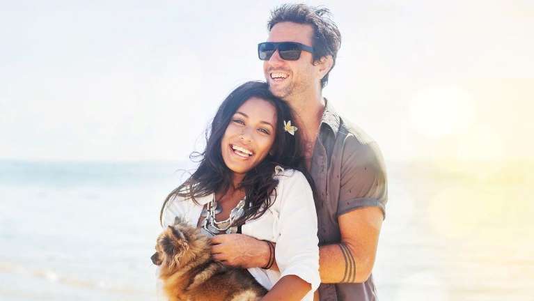 Couple smiling on beach | Cosmetic Dentist Warners Bay