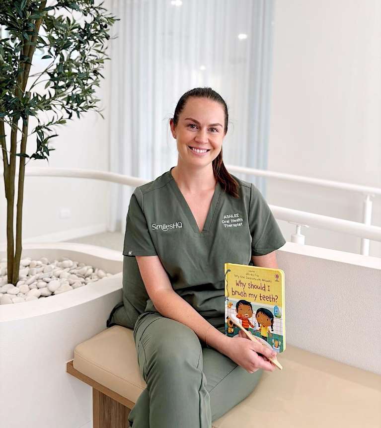 Our oral health therapist Ashlee holding children's book