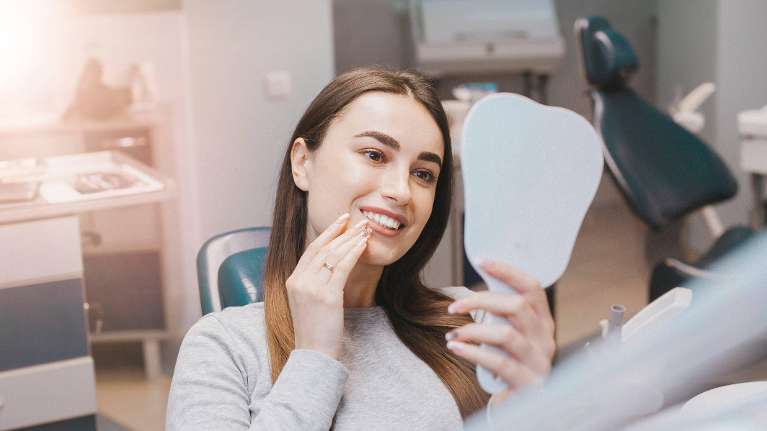 Woman appreciating new smile | Warners Bay Dentist