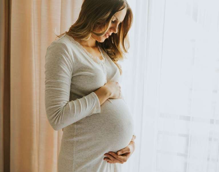 pregnant woman holding stomach 