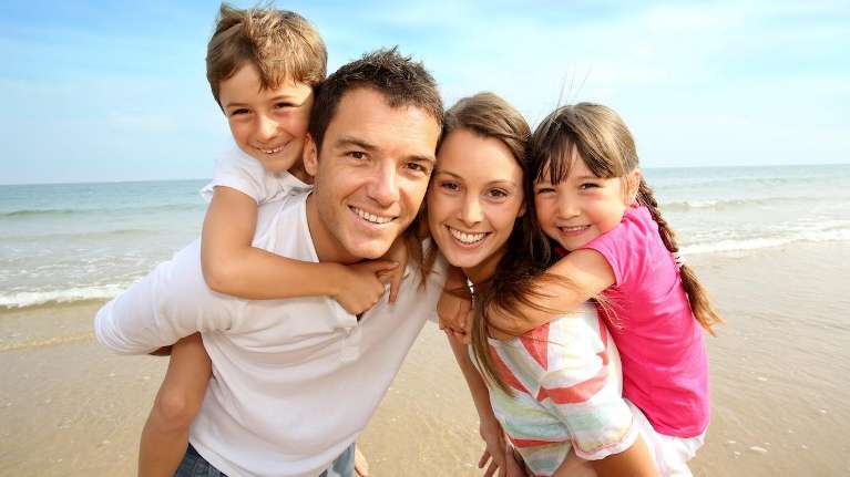 mom, dad, son, and daughter smiling