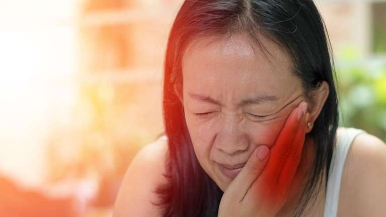 warners bay woman holding jaw from pain during dental emergency 