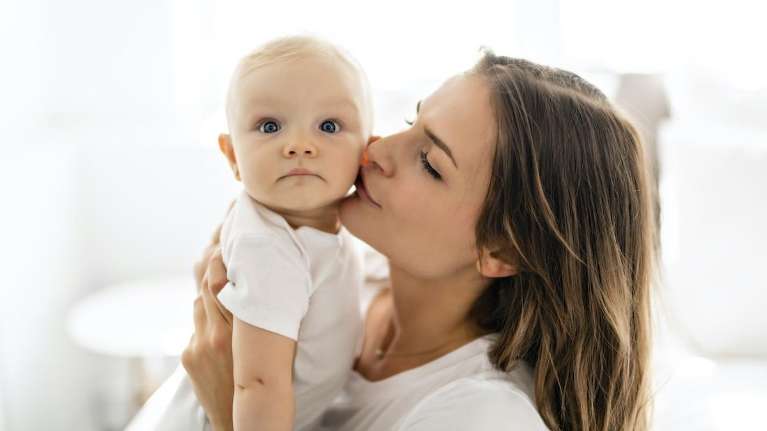 mother kissing her baby on the cheek
