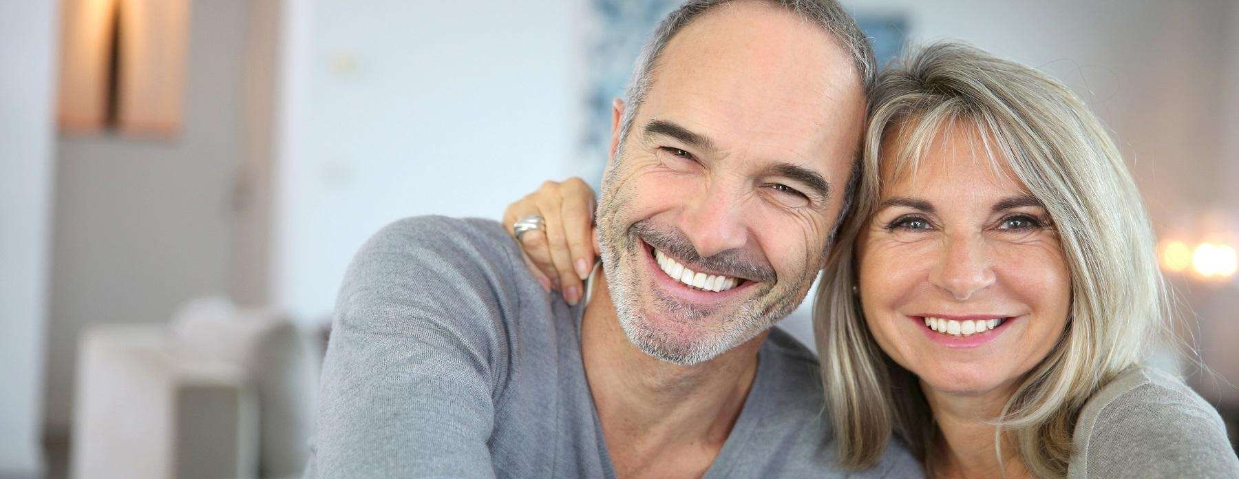 smiling couple with dental implants in warners bay