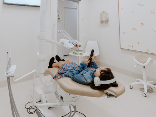 woman wearing Noise-Cancelling Headphones at warners bay dental clinic