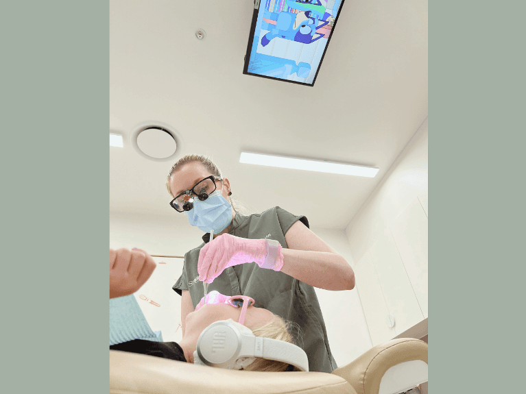 woman wearing Noise-Cancelling Headphones at warners bay dental clinic